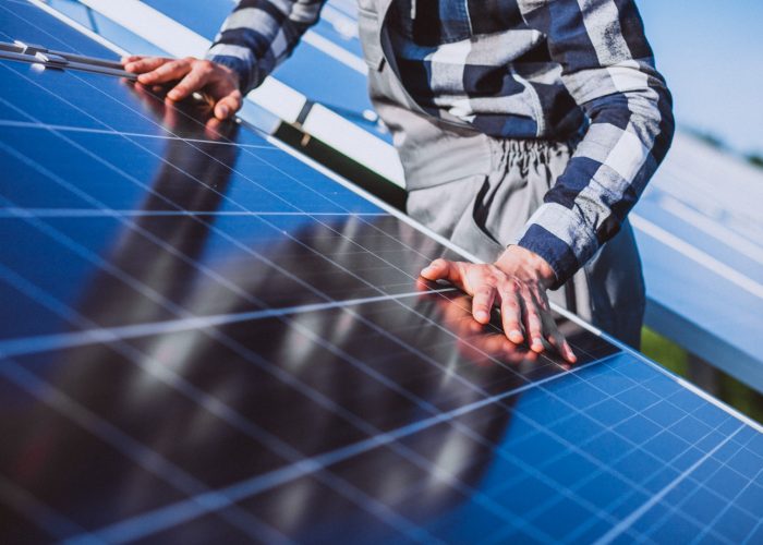 Man worker in the firld by the solar panels